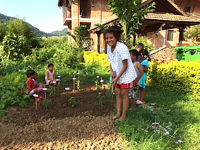 Big sister Rama gives the little ones some lessons in gardening.