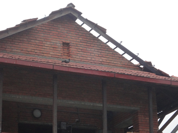 The storm tore tiles off all our overhanging roof areas.