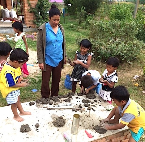 Uma helps the little ones to get creative with mud!